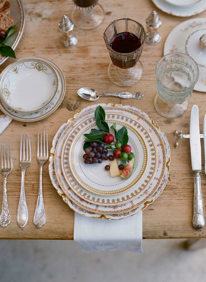 Vintage china in an elegant placesetting at a rustic farm table - rich and elegant tablescape inspiration - photo by Elizabeth Messina. #placesetting #romantictablescape #vintagestyle