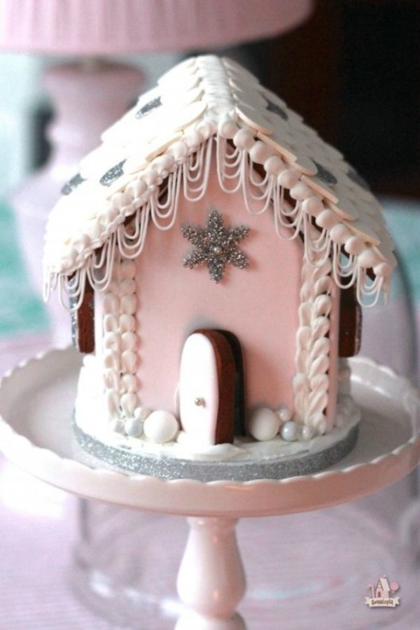 Charming pink gingerbrread house on a pedestal. #pinkchristmas #christmasbaking #gingerbreakhouse #candyhouse