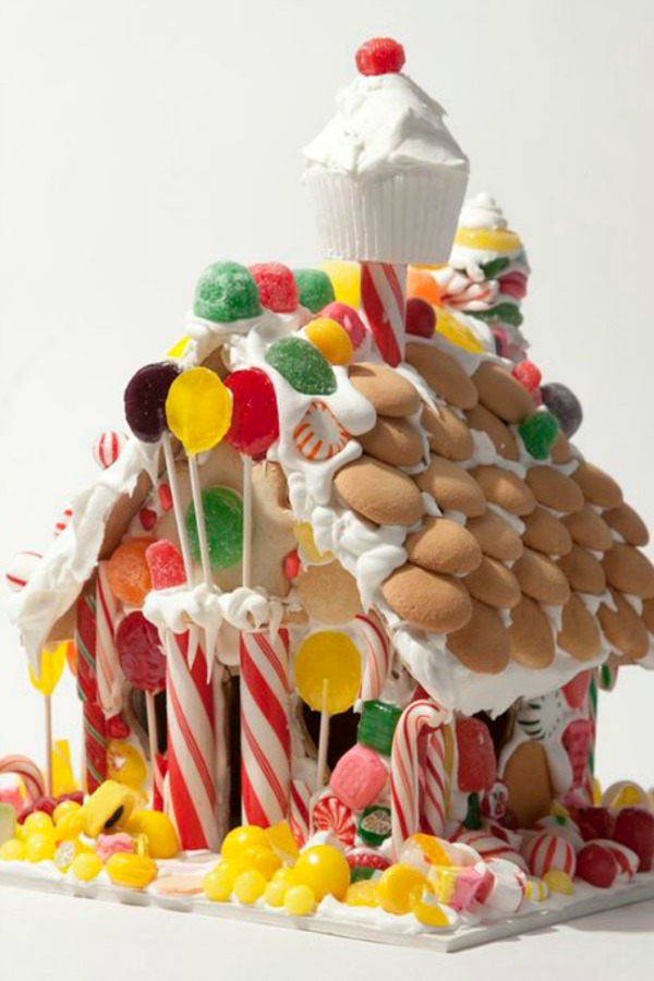 Cupcake chimney on a fanciful candy house decorated with vanilla wafers. #gingerbreadhouse #christmasbaking #holidaydiy