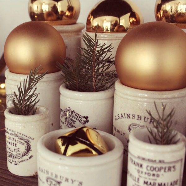 Vintage marmalade jars with greenery and gold bulbs in my Christmas home - Hello Lovely Studio. #christmasdecor #hellolovelystudio #vintagechristmas