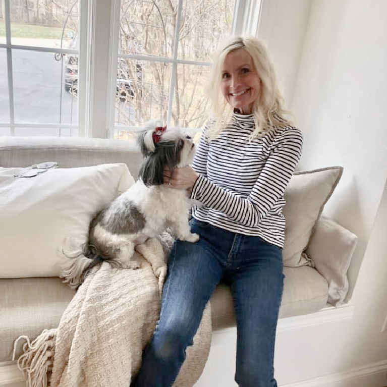 Michele of Hello Lovely with shih tzu on window seat in kitchen.