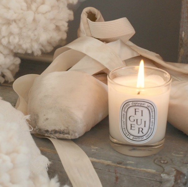 Vignette de décoration de Noël blanche avec bougie Diptyque, couronnes de pompons et chaussons de ballet - Hello Lovely Studio. #christmasdecor #pompomwreath #christmaswreath #pinkchristmas
