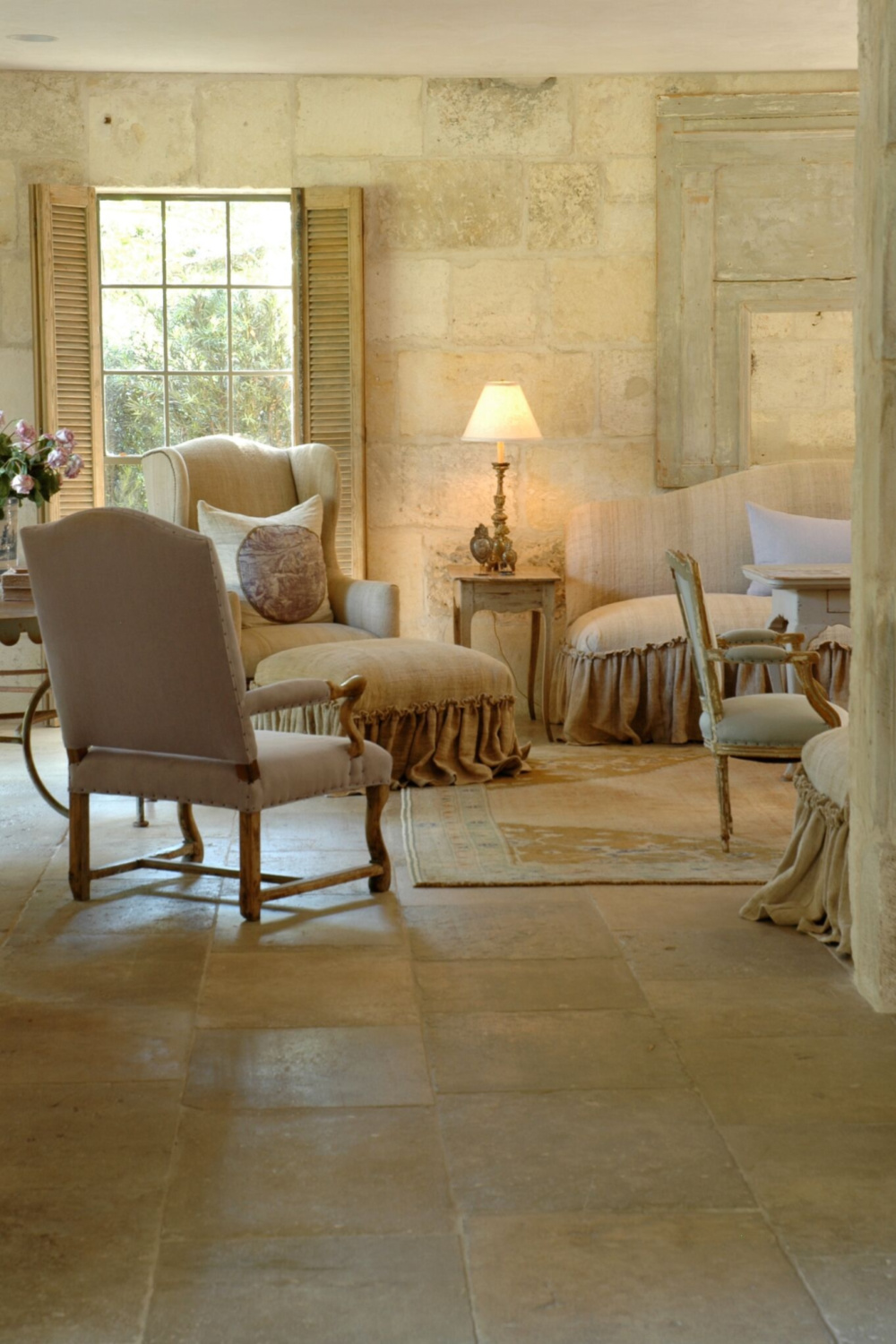 French country living room with reclaimed antique stone floors and walls. Chateau Domingue. Design by Pamela Pierce.