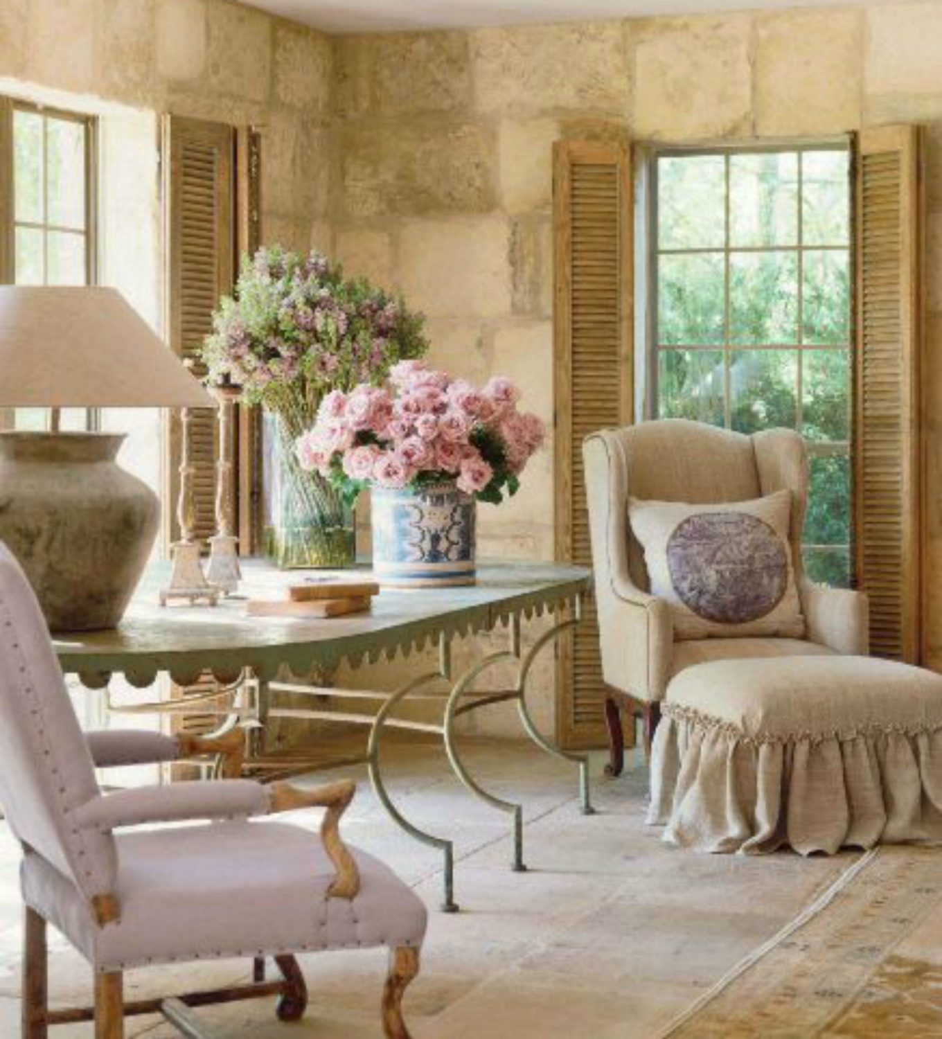 French farmhouse living room with antiques, limestone, and shutters on Hello Lovely Studio #chateaudomingue #Frenchfarmhouse #PamelaPierce