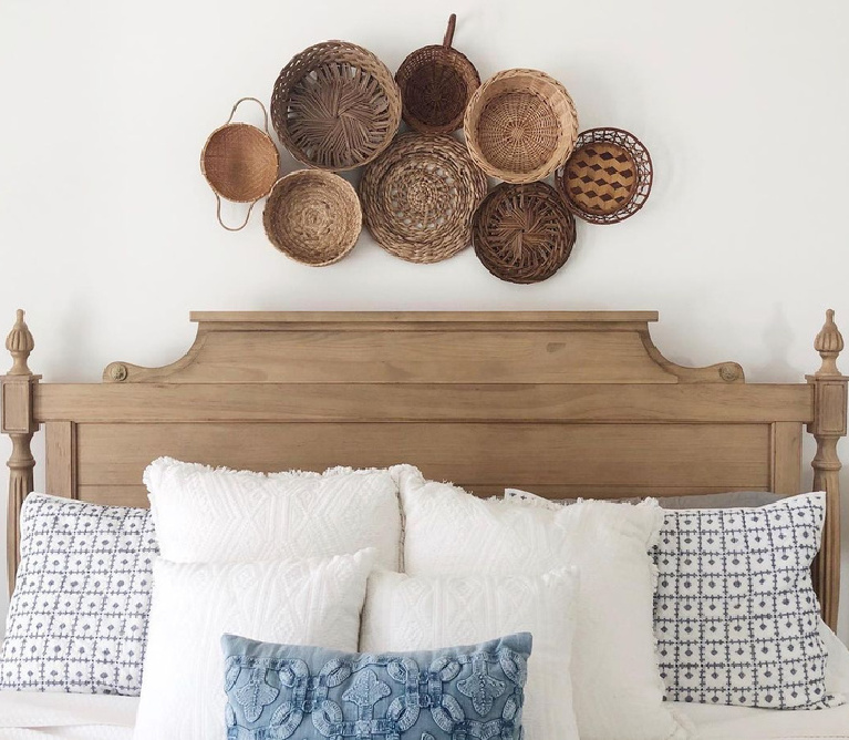 Chantilly Lace white paint color on walls of a beautiful bedroom with baskets above bed - @farmcasadecastro. #chantillylace #whitepaint #benjaminmoorechantillylace