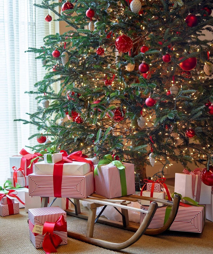 Atlanta Home for Holidays Christmas tree with red ornaments, ribbons, and festive gifts with wood sled - AHL.