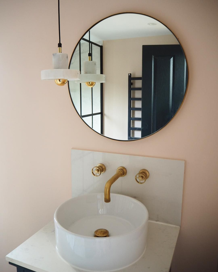 Farrow & Ball Pink Ground paint color on walls of a lovely powder room with vessel sink, brass taps, and round mirror - HouseLust.