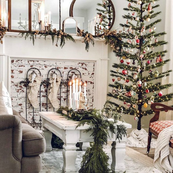 White farmhouse Christmas decorated living room with vintage design elements - Le Cultivateur. #holidaydecor #christmasdecor #livingroom #farmhousechristmas #whitechristmas