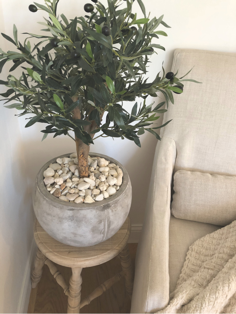 Stunning olive tree in rustic pot (Nearly Natural) on teak farmhouse stool with Belgian linen chair in my breakfast room - Hello Lovely Studio.