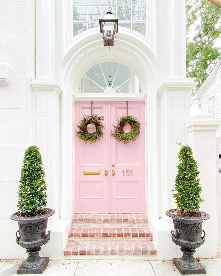 Gorgeous fresh pink painted doors with Christmas wreaths on a Charleston home - @sarahweisbrod