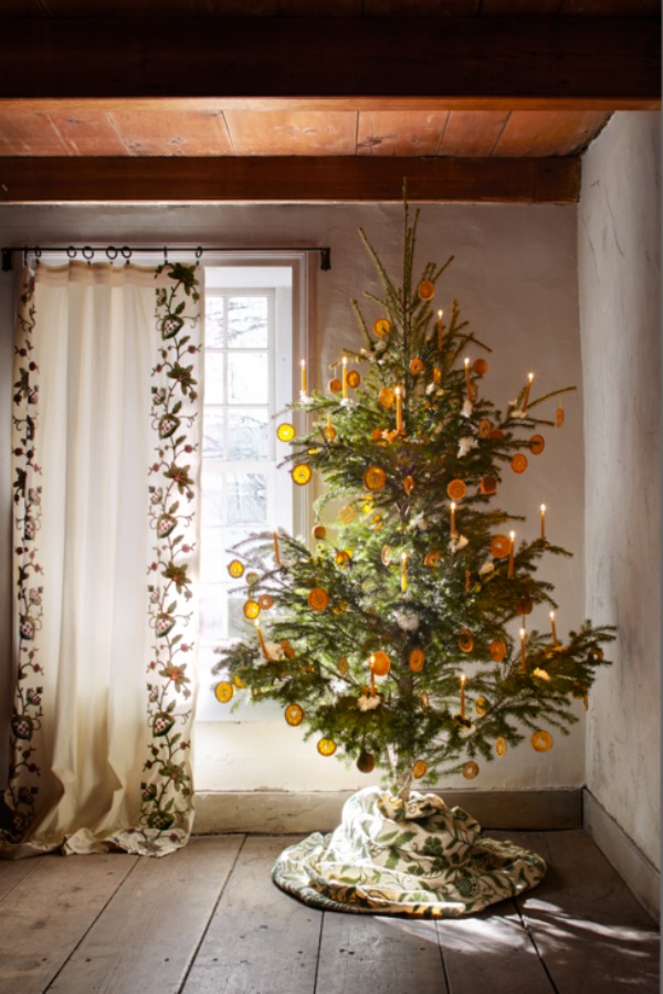 Dried orange garland on a Christmas tree. Floral designer Michael Putnam reimagined holiday décor with fresh blooms and artful twists on traditional topiaries, garlands, and wreaths within this 18th-century New York farmhouse - Veranda. #christmasdecor #christmastrees #scandinavian