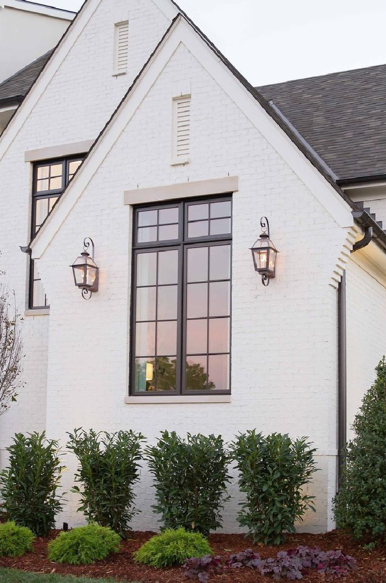 White brick house exterior with Shoji White (Sherwin Williams), design by @mrsparanjape and photo by Kristen Mayfield. #shojiwhitepaint #shojiwhite #whitepaintcolors #whitebrick