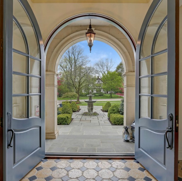 Arched French door entry in a magnificent French country mansion in Hinsdale, Illinois. #frenchcountry #luxuryhome #entry #archeddoors