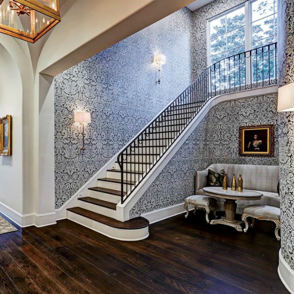 Farrow & Ball Silvergate wallpaper near staircase in an elegant French country mansion in Houston by Thomas O'Neill Homes.