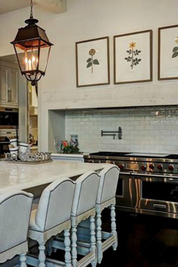 Luxurious white French country kitchen with lantern pendants and white cabinets in a Houston manse by TOH. #frenchcountry #kitchendesign #whitekitchens #elegantdecor