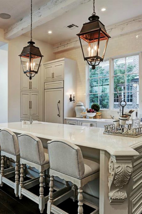 Luxurious white French country kitchen with lantern pendants and white cabinets in a Houston manse by TOH. #frenchcountry #kitchendesign #whitekitchens #elegantdecor