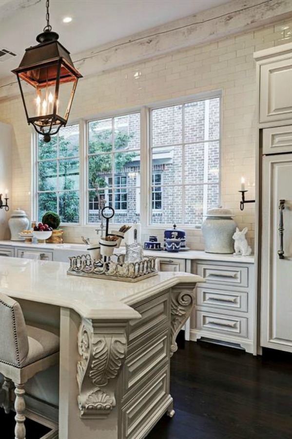 Luxurious white French country kitchen with lantern pendants and white cabinets in a Houston manse by TOH. #frenchcountry #kitchendesign #whitekitchens #elegantdecor