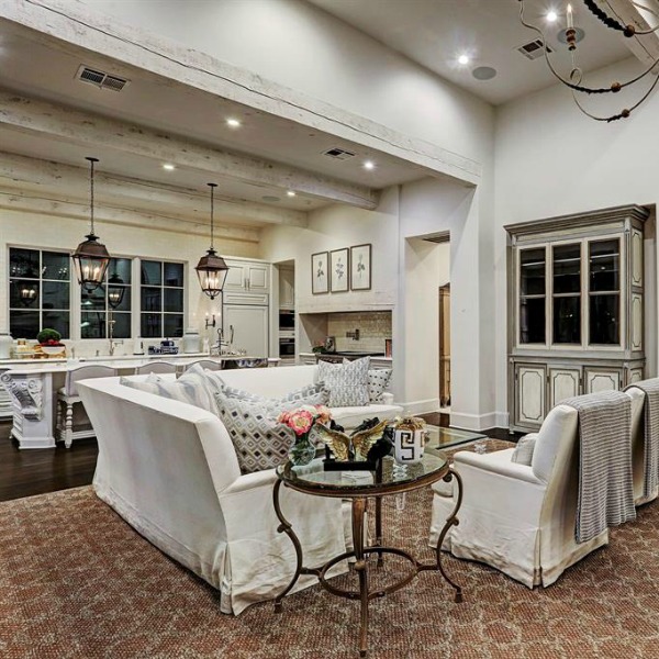 Luxurious white French country living room with black steel windows and French fireplace. #frenchcountry #livingroom #interiordesign #luxuryhome