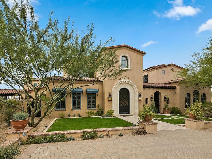 Elegant French Country home exterior in Scottsdale with stucco and arched doors. #houseexterior #frenchcountry #scottsdale