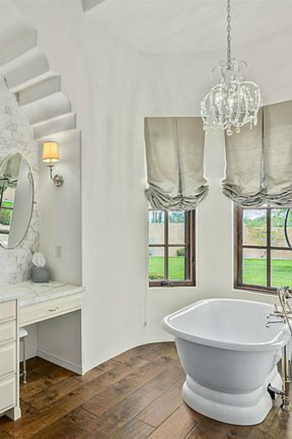 Luxurious and sophisticated white marble French inspired bathroom with freestanding tub and warm wood flooring. #luxuriousbathroom #bathroomdesign #frenchcountry