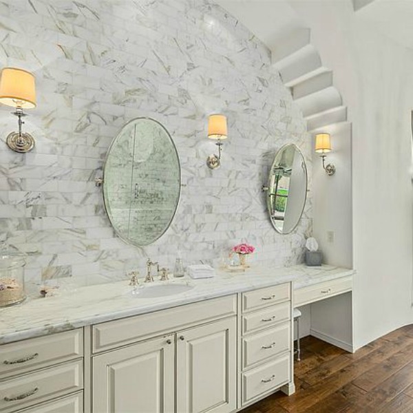 Luxurious and sophisticated white marble French inspired bathroom with freestanding tub and warm wood flooring. #luxuriousbathroom #bathroomdesign #frenchcountry