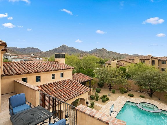 Elegant French Country home exterior in Scottsdale with stucco and arched doors. #houseexterior #frenchcountry #scottsdale