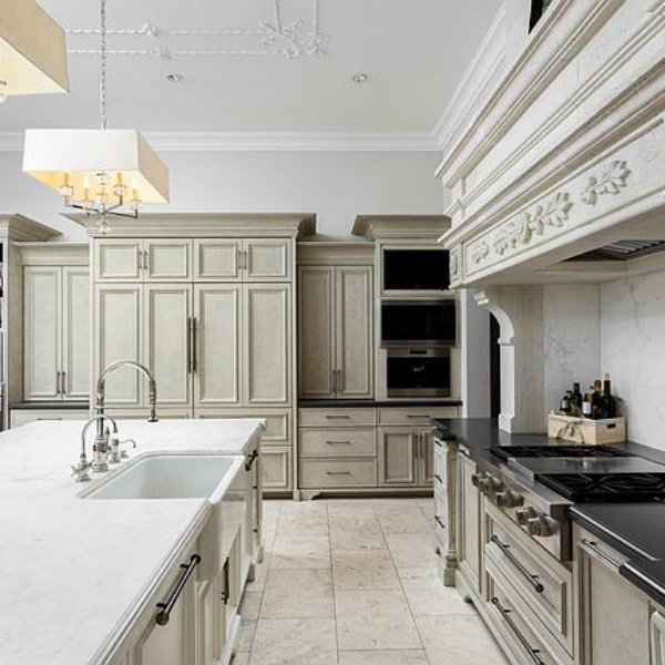 Sophisticated white French country kitchen with Louis style counter stools in a magnificent and classic Scottsdale home. #kitchendesign #frenchcountry #luxuriouskitchen #scottsdalehome