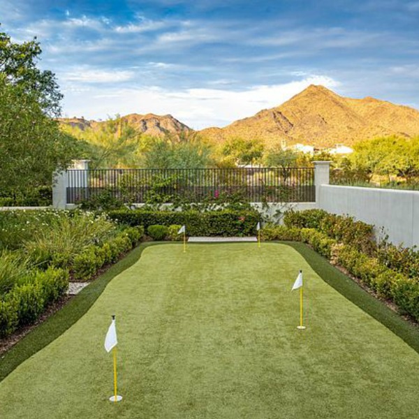 Luxurious mountain view backyard with putting green at a classic French inspired Scottsdale home.