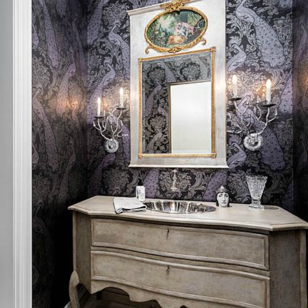 Elegant powder bath with black peacock wall covering, French country vanity, and charming sconces. #powderbath #frenchcountry #luxuriousbathroom