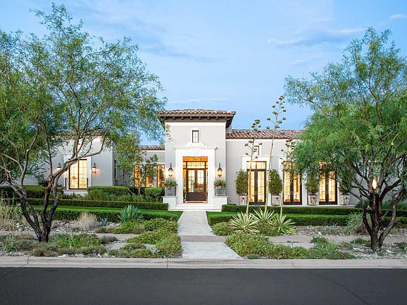 Classic, elegant luxurious house exterior in Scottsdale with tile roof, stucco, and French doors. #houseexterior #luxurioushome #scottsdalehome