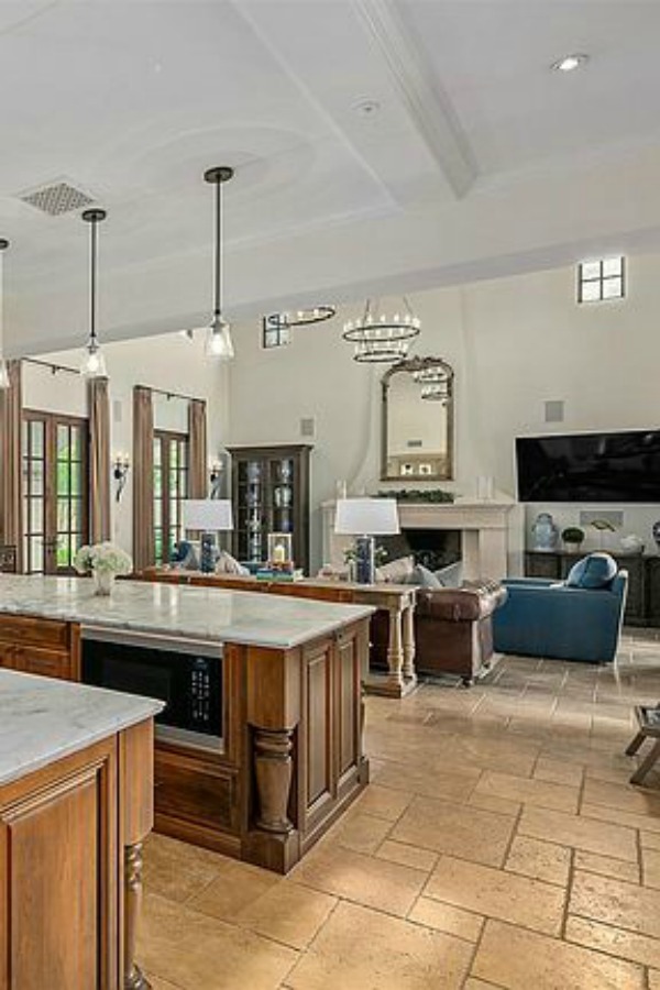 Double islands in elegant French country kitchen in luxurious Scottsdale home with stone floor, two tone cabinets, farm sink, and arch doorways. #luxuriouskitchen #frenchcountrykitchen #elegantdecor #kitchendesign