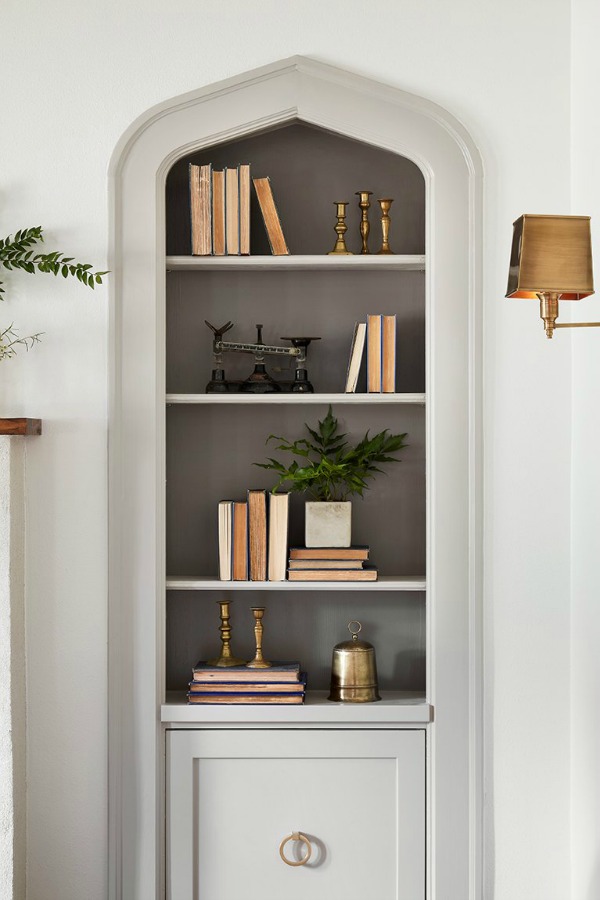 Built-in book shelves in living room.  Come get inspired by Tranquil and Timeless Tudor Design Details From a Serene 1920s Texas Cottage renovated on HGTV's Fixer Upper by Chip and Joanna and known as the Scrivano House. #fixerupper #scrivano #cottagestyle #interiordesign #greytrim #serenedecor #builtin #bookshelves #livingroom