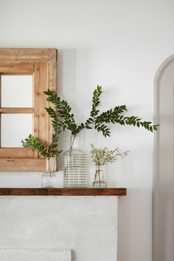 Simple mantelscape.  Come get inspired by Tranquil and Timeless Tudor Design Details From a Serene 1920s Texas Cottage renovated on HGTV's Fixer Upper by Chip and Joanna and known as the Scrivano House. #fixerupper #scrivano #cottagestyle #interiordesign #greytrim #serenedecor #fierplace #mantelscape #simpledecor