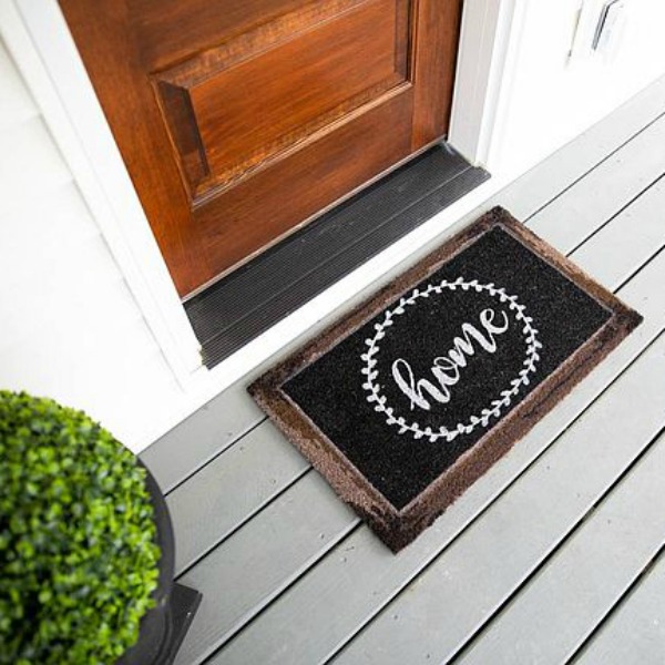 Whimsical black and white door mat at entrance to urban farmhouse with rustic wood door. #frontdoor #urbanfarmhouse #doormat #blackandwhitedecor