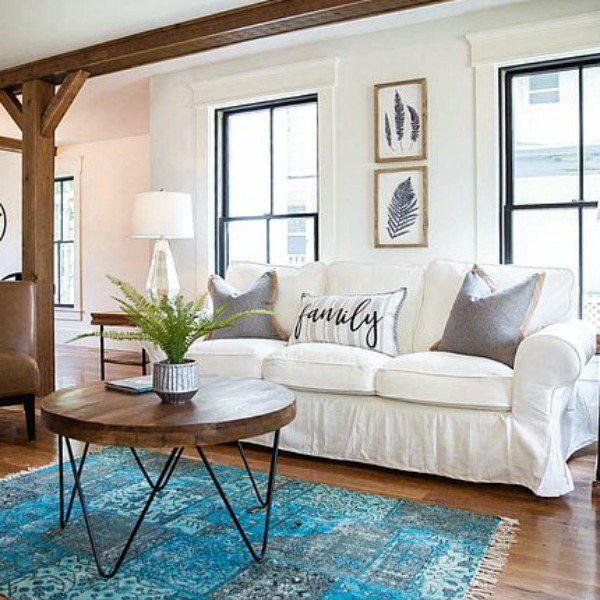 Urban farmhouse living room design with rustic beams, black windows, wood floors, and white sofa. #hellolovelystudio #urbanfarmhouse #interiordesign #modernfarmhouse #livingroom