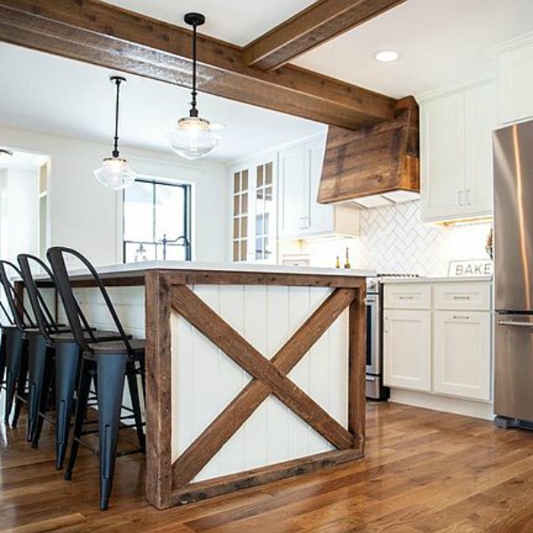 Urban farmhouse kitchen design with rustic beams, island, and metal stools. #hellolovelystudio #urbanfarmhouse #farmhousekitchen #modernfarmhousekitchen