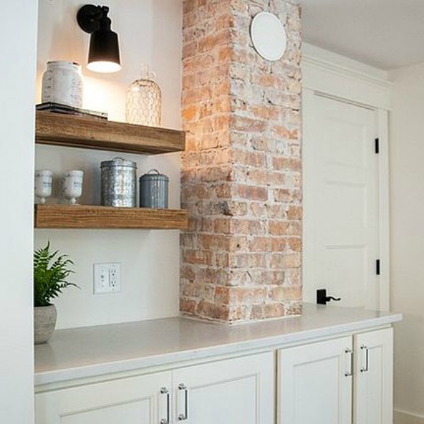 Exposed brick in an urban farmhouse kitchen design with rustic beams, island, and metal stools. #hellolovelystudio #urbanfarmhouse #farmhousekitchen #modernfarmhousekitchen