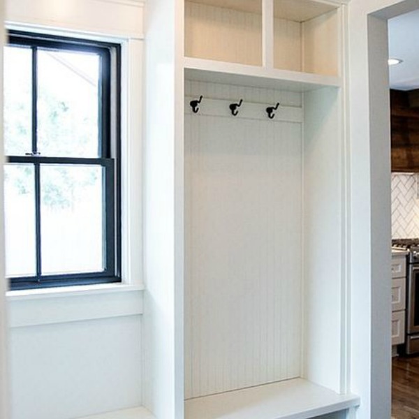 Beautiful modern farmhouse mud room with built-ins and beadbord. Urban Farmhouse in Beloit, Wisconsin & rustic interior design ideas to get the look. #hellolovelystudio #blackandwhitedecor #urbanfarmhouse #modernfarmhouse #interiordesign #renovatedfarmhouse