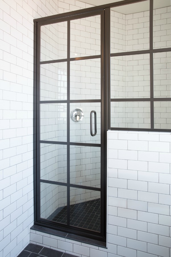 Black shower door and white subway tile in modern farmhouse style bathroom by Jaimee Rose Interiors.