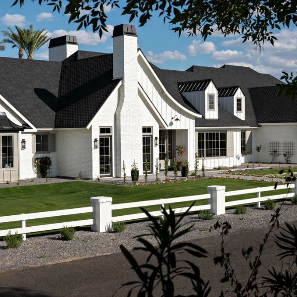 Classic white modern farmhouse exterior with black roof and Tudor influences. #interiordesign #modernfarmhouse #houseexterior