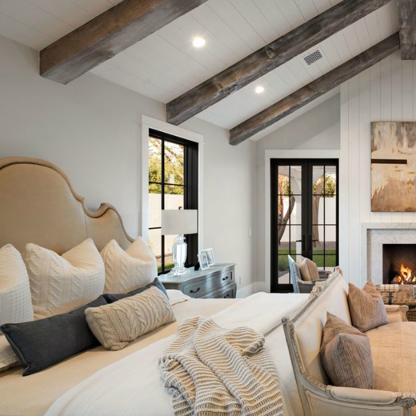 Modern farmhouse bedroom with fireplace, shiplap, and black painted French doors. Interior design by Jaimee Rose Interiors. #bedroomdesign #modernfarmhouse #interiordesign