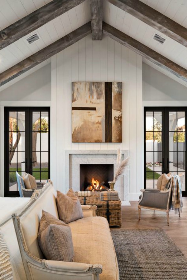 Modern farmhouse bedroom with fireplace, shiplap, and black painted French doors. Interior design by Jaimee Rose Interiors. #bedroomdesign #modernfarmhouse #interiordesign