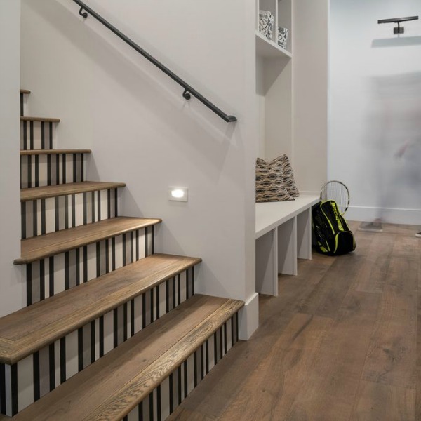 Decorative pattern on stair riser near a modern farmhouse mud room with staircase and built-ins. Jaimee Rose Interiors.