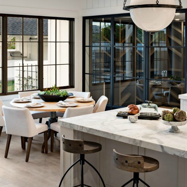 Black and white industrial modern farmhouse kitchen with steel windows and marble countertops - Jaimee Rose Interiors.