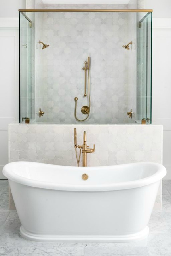 Beautiful white marble bathroom with soaker tub and brass fixtures - Jaimee Rose Interiors. #bathroomdesign #soakertub #brassfixtures