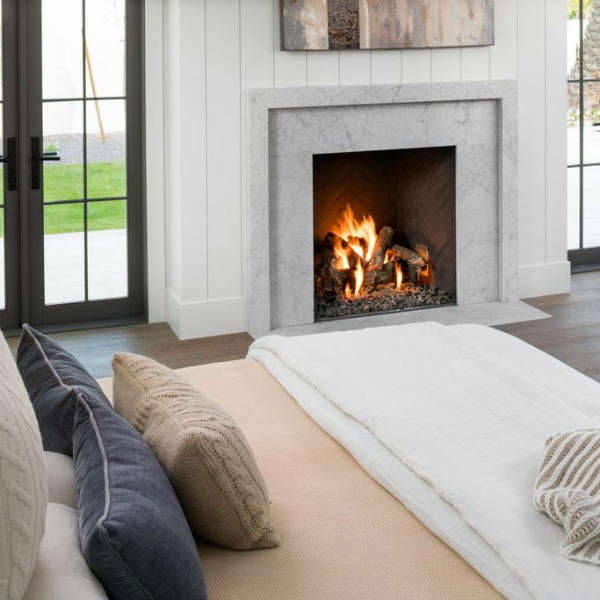 Modern farmhouse bedroom with fireplace, shiplap, and black painted French doors. Interior design by Jaimee Rose Interiors. #bedroomdesign #modernfarmhouse #interiordesign