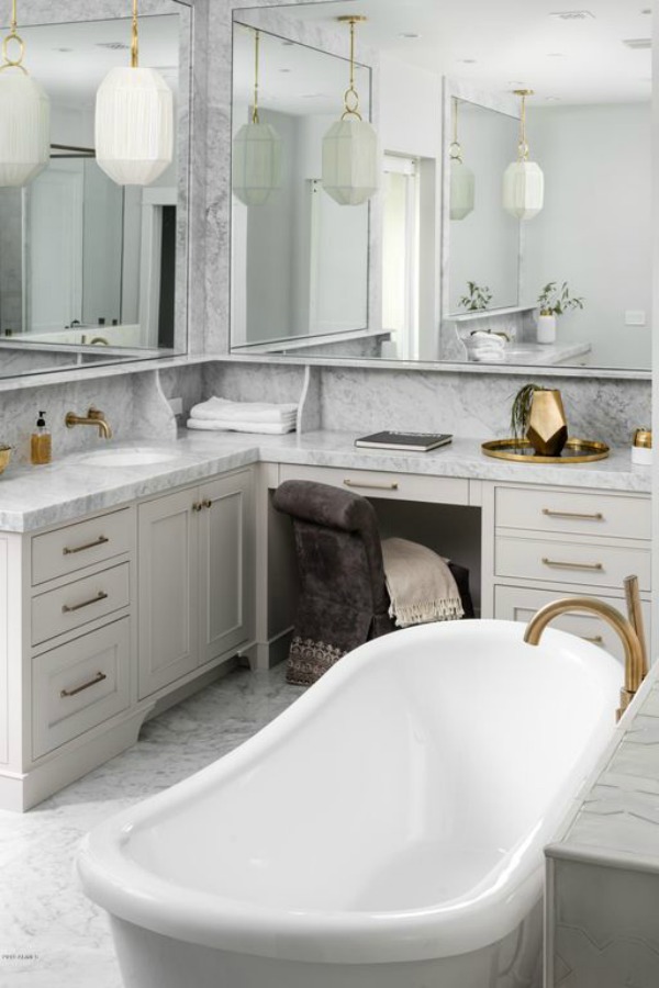 Luxurious white marble bathroom with vanity area, modern geometric pendants, and brass fixtures and hardware - Jaimee Rose Interiors.
