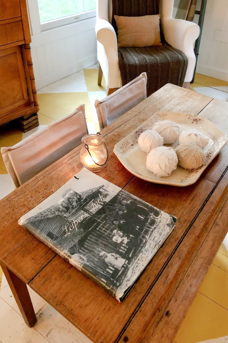 Brown transferware antique platter with balls of wrapped cloth and a candle upon a wood table - Hello Lovely Studio.