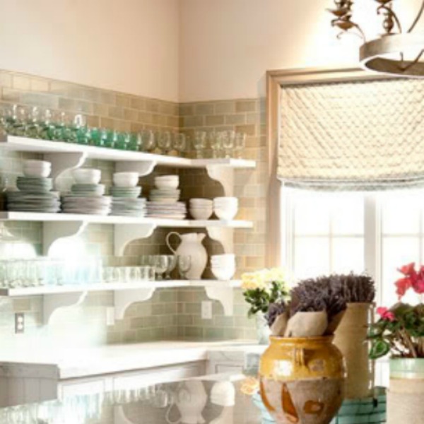 Open white kitchen shelves and green subway tiles in white French kitchen (Decor de Provence). Come tour French Fantasy House Build: A Timeless Tranquil Home Favorite!