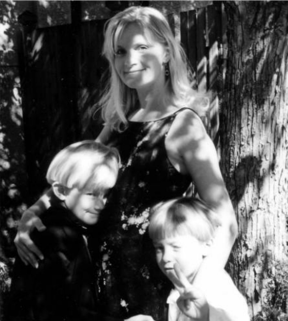 Michele of Hello Lovely Studio with her young sons in dappled light beneath a tree.